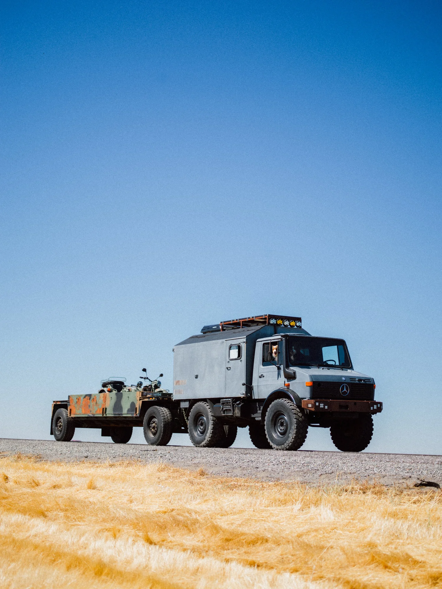 Unimog expedition truck and trailer on an open road