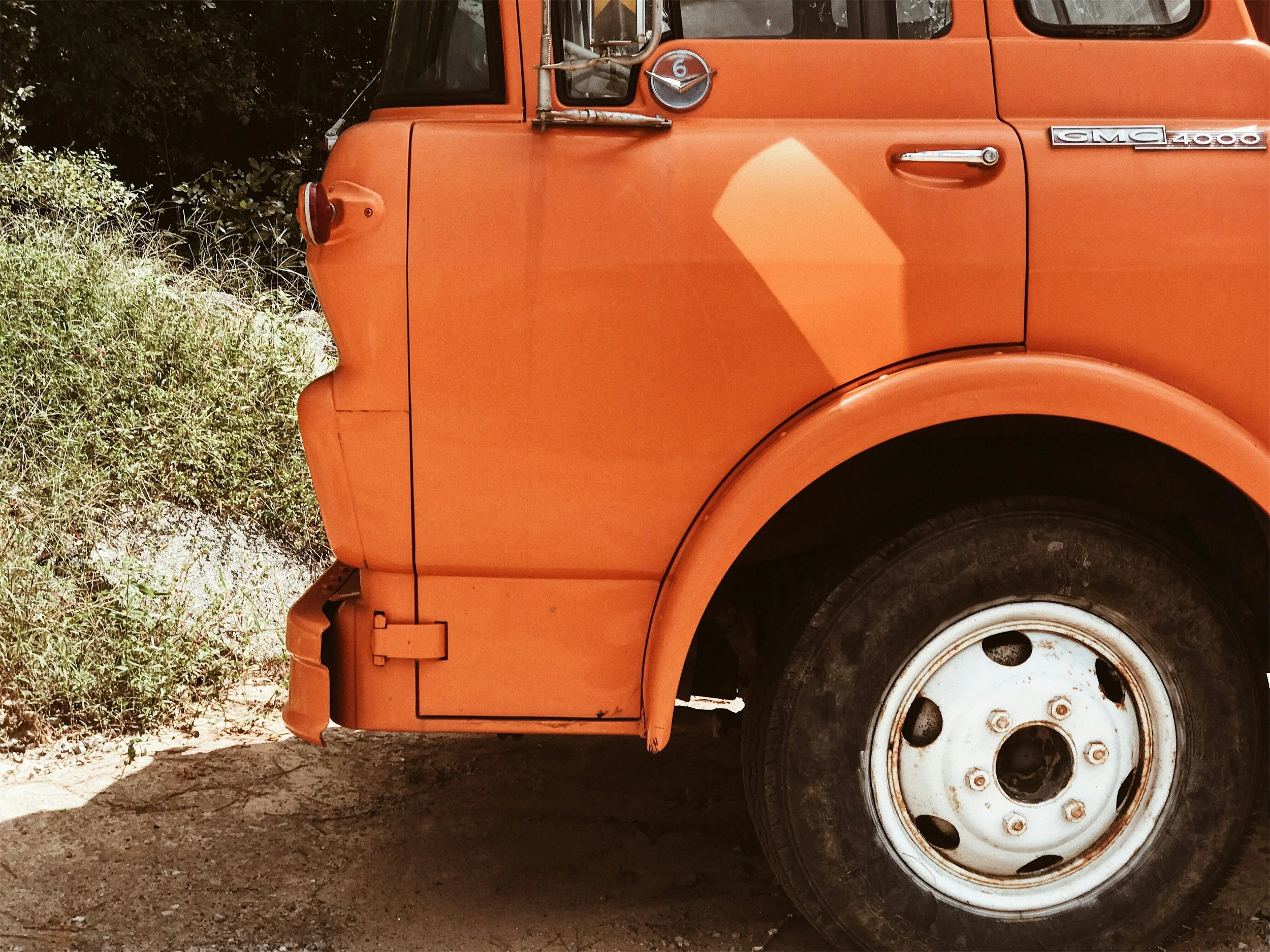 The character and detail of a vintage orange GMC truck